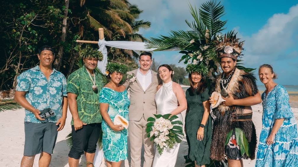 A newly married couple with Jane, family wearing ei katu and a traditionally dressed warrior holding a pū shell